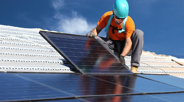 Worker installing solar panel on roof. Union.