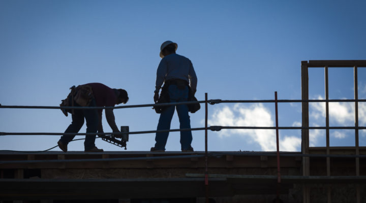 Construction Workers Silhouette on Roof of Building.